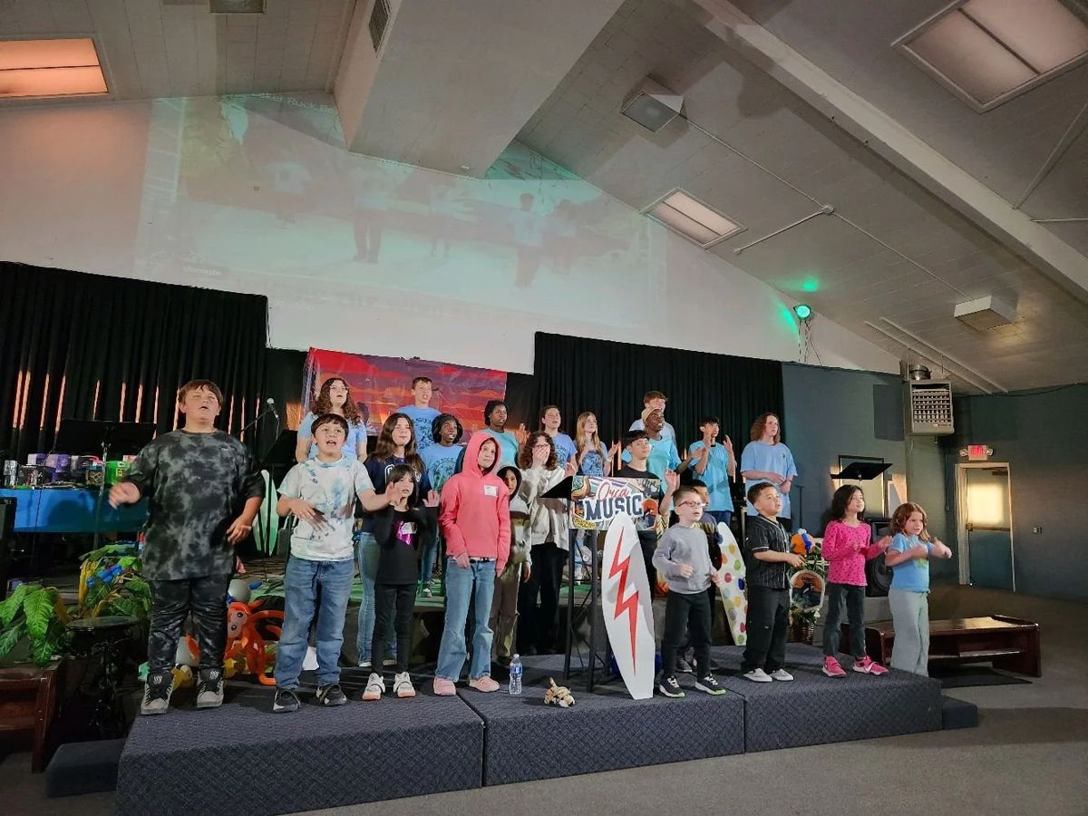 A large group of kids singing on stage