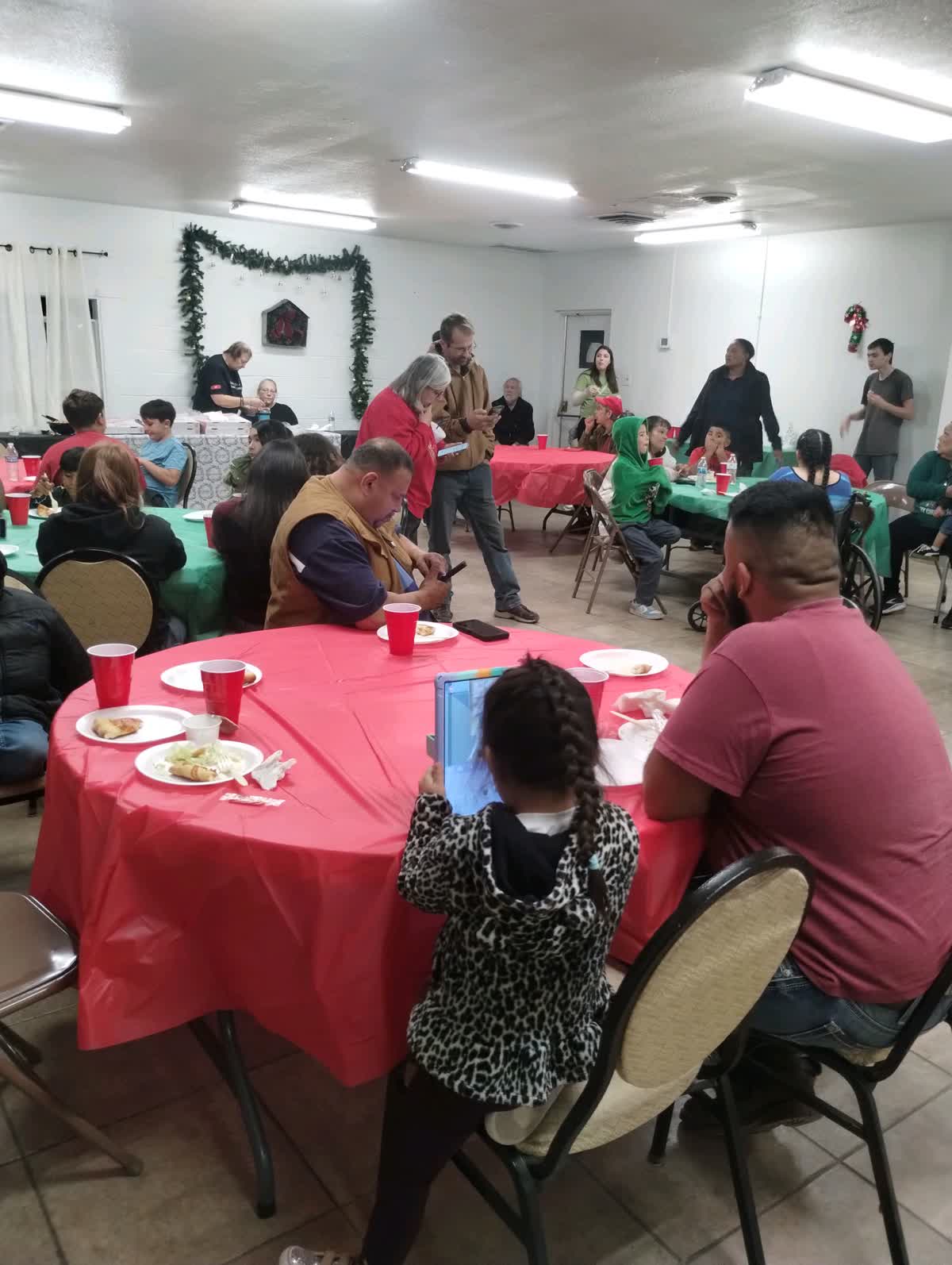 Families at red tables at a Christmas dinner