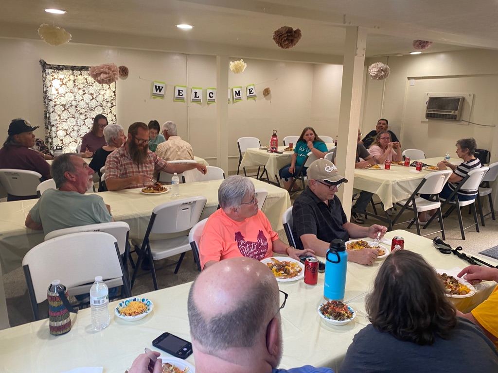 Neighbors sharing a meal at round tables