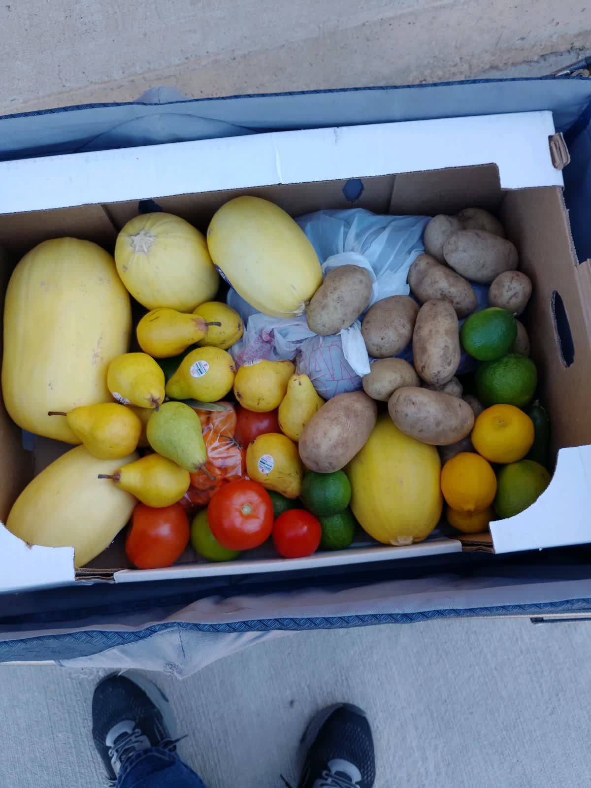A box of fresh fruit and potatoes