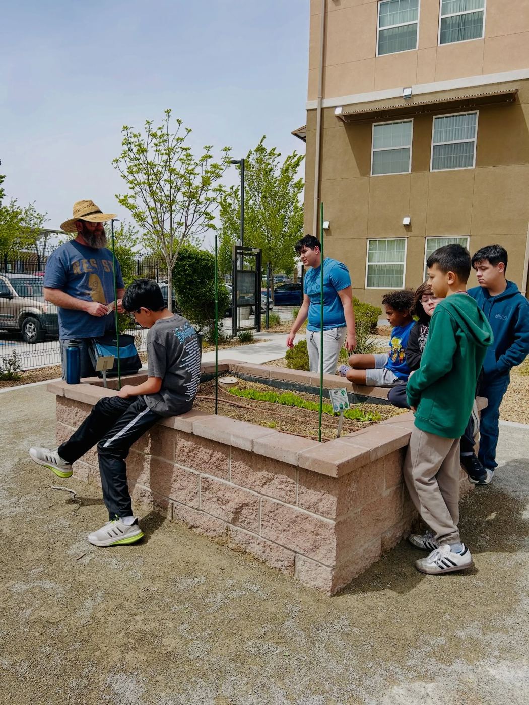 Residents and volunteers working a raised garden bed