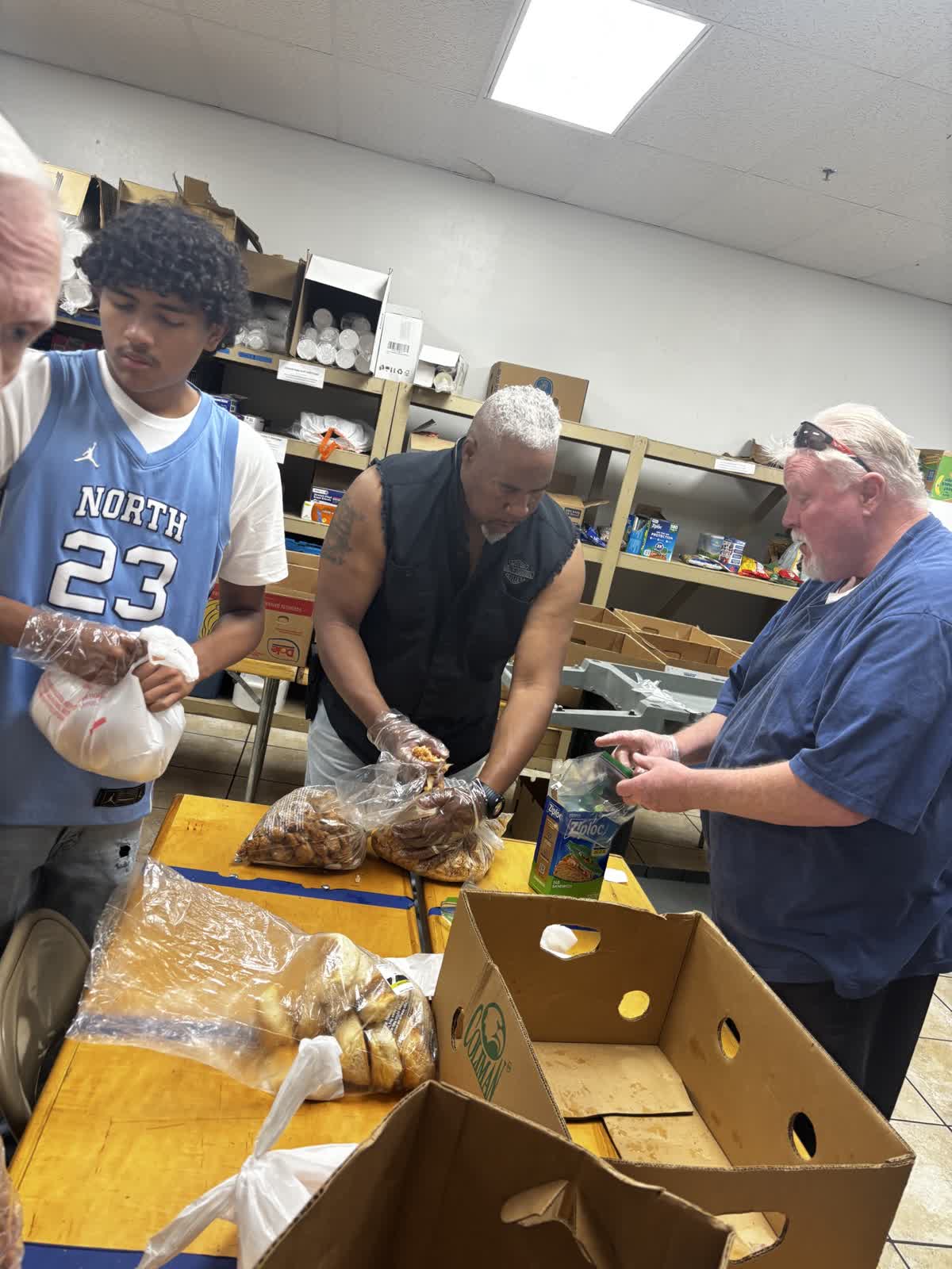 Teens and volunteers packing food together