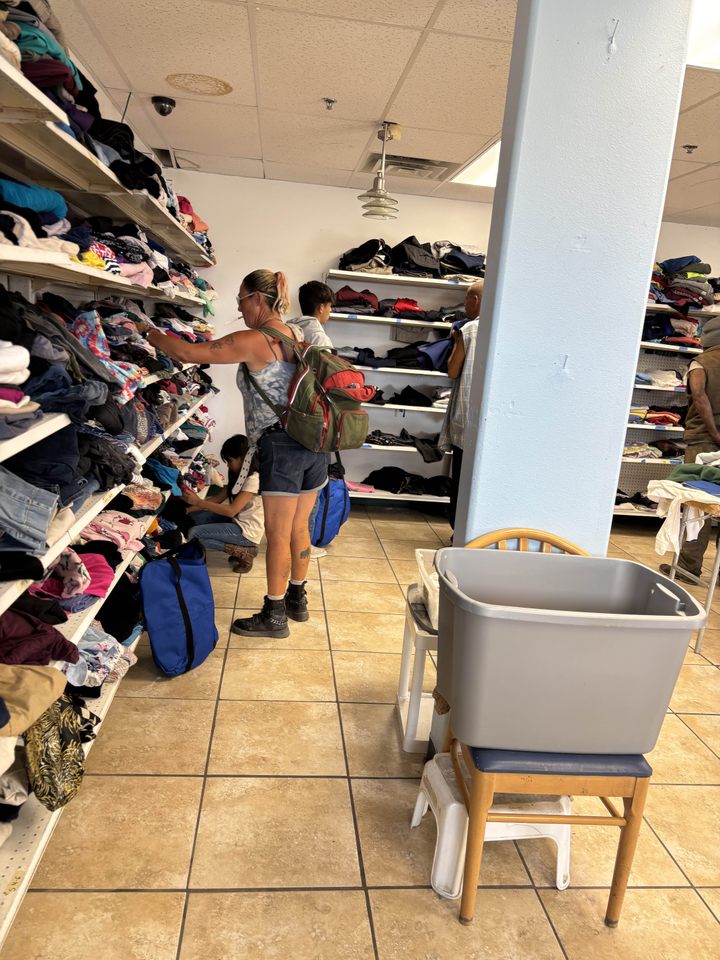 Teens sorting clothing on racks in the Free Store