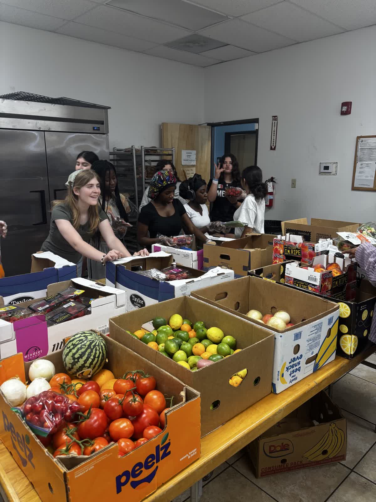 Teens packing boxes of fresh produce in the food bank